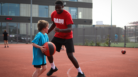 a child and an adult playing basketball